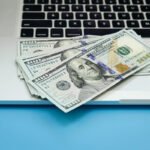 UK beginner working on laptop and smartphone showing the top 10 best side hustles to earn money online and offline in 2026